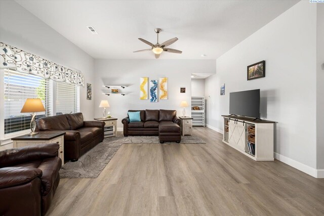 living room featuring baseboards, ceiling fan, wood finished floors, and visible vents