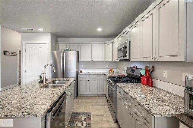 kitchen featuring visible vents, appliances with stainless steel finishes, light wood-type flooring, a sink, and recessed lighting