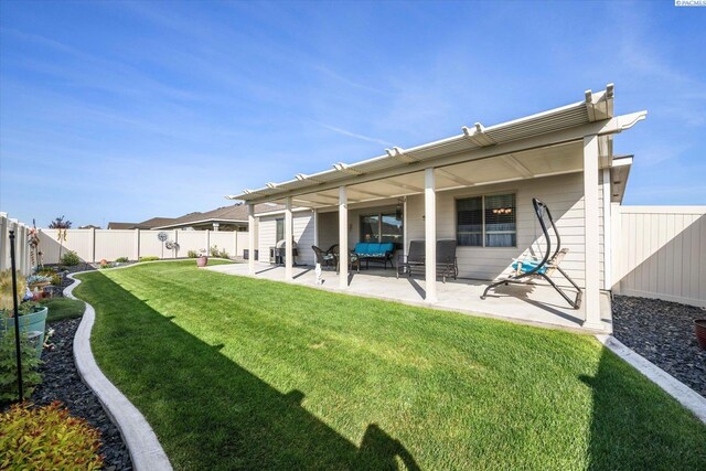 rear view of property with a fenced backyard, a yard, and a patio area