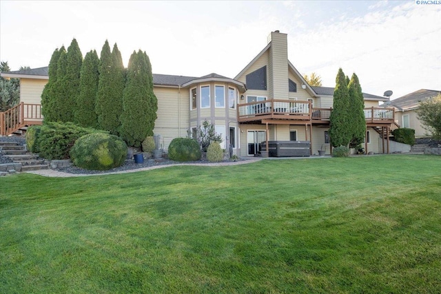 rear view of property featuring a hot tub, stairs, a chimney, and a deck