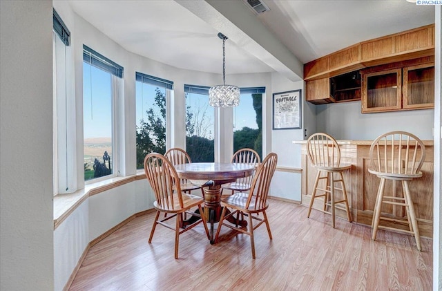 dining area featuring an inviting chandelier, light wood-style flooring, and a wealth of natural light