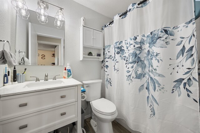 506 W 19th Ave, Kennewick, WA 99337 - full bath with vanity, wood finished floors, a textured wall, and a shower with shower curtain