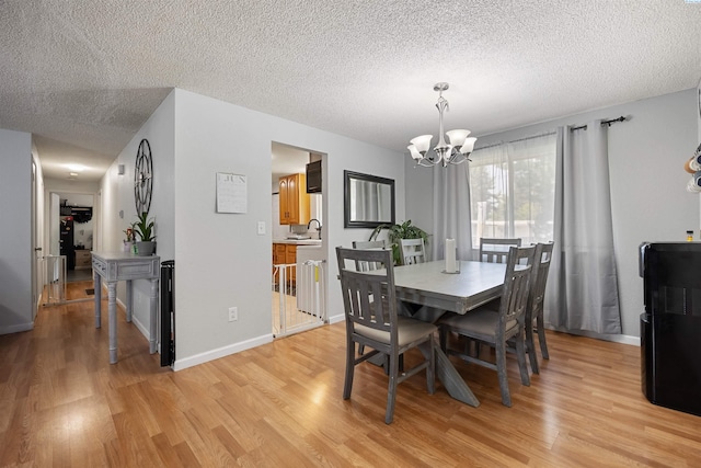 506 W 19th Ave, Kennewick, WA 99337 - dining room featuring light wood-type flooring, a chandelier, and a textured ceiling