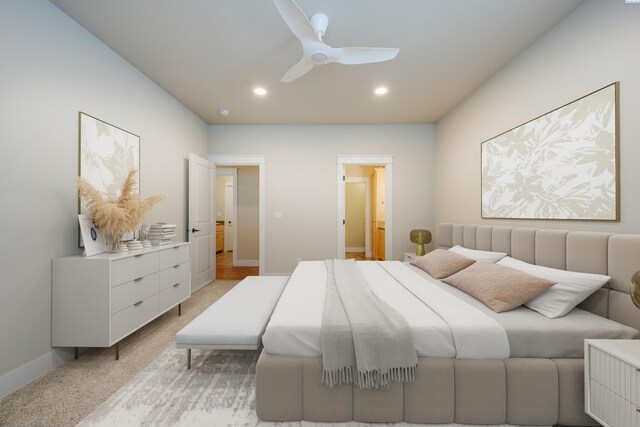 carpeted bedroom with ceiling fan and ensuite bath