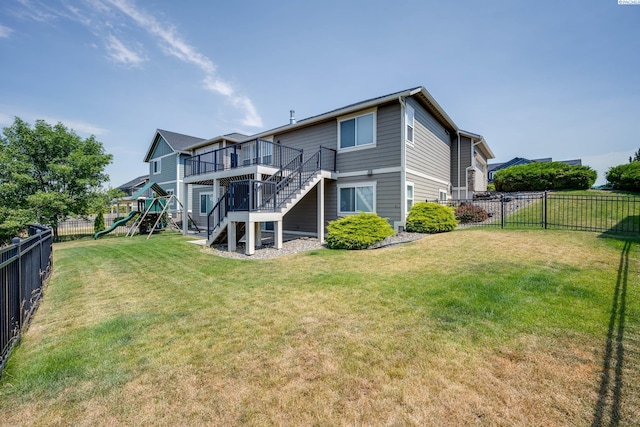 back of house with a lawn, a playground, and a deck