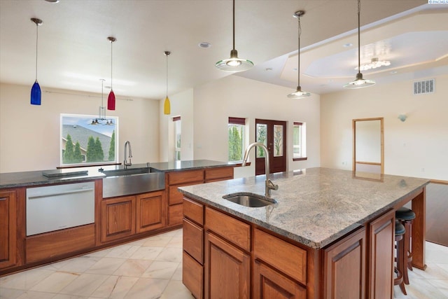 kitchen featuring decorative light fixtures, a kitchen island with sink, sink, and dishwasher