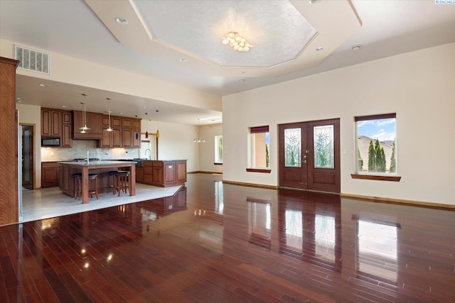 foyer featuring sink, a notable chandelier, dark hardwood / wood-style flooring, and a tray ceiling