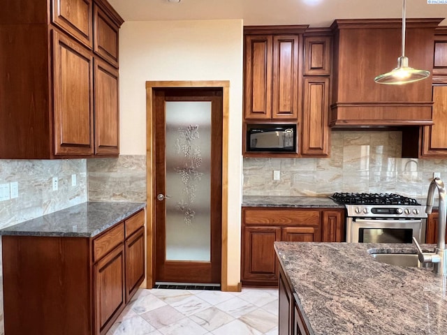 kitchen featuring hanging light fixtures, decorative backsplash, stainless steel range with gas cooktop, and black microwave