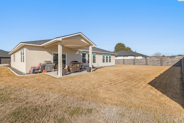 back of house featuring a yard, fence, a patio, and stucco siding