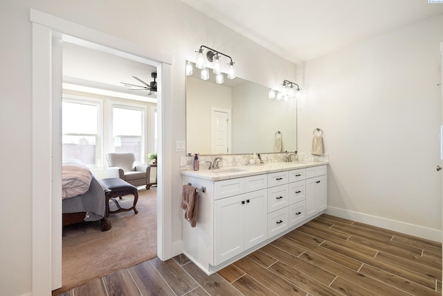 bathroom with connected bathroom, a sink, and wood finished floors