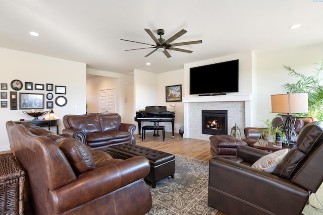 living area featuring a fireplace, wood finished floors, a ceiling fan, and recessed lighting