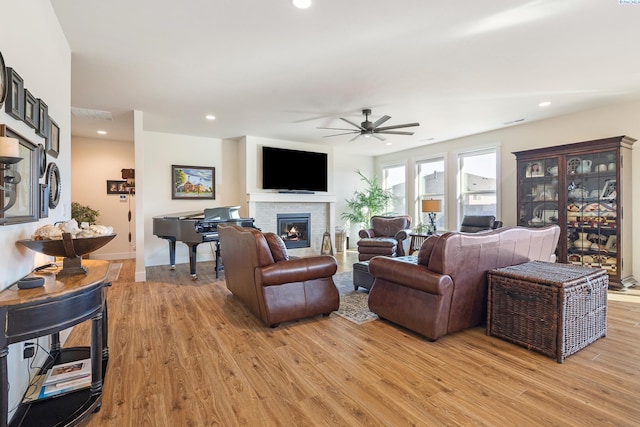 living room with light wood finished floors, a fireplace, visible vents, and recessed lighting