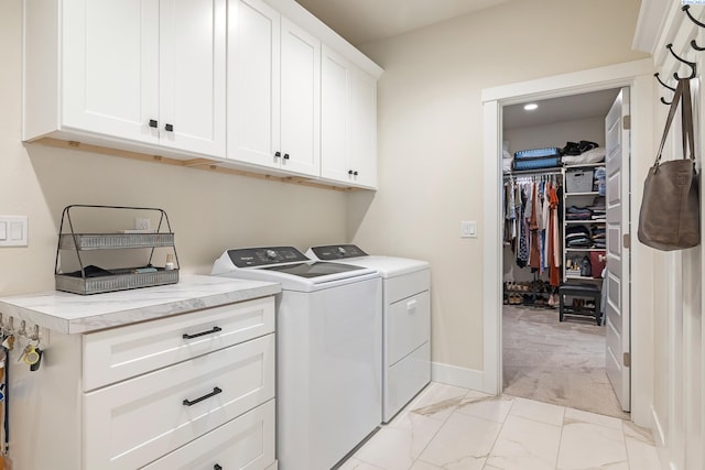 laundry area with light carpet, cabinet space, baseboards, independent washer and dryer, and marble finish floor