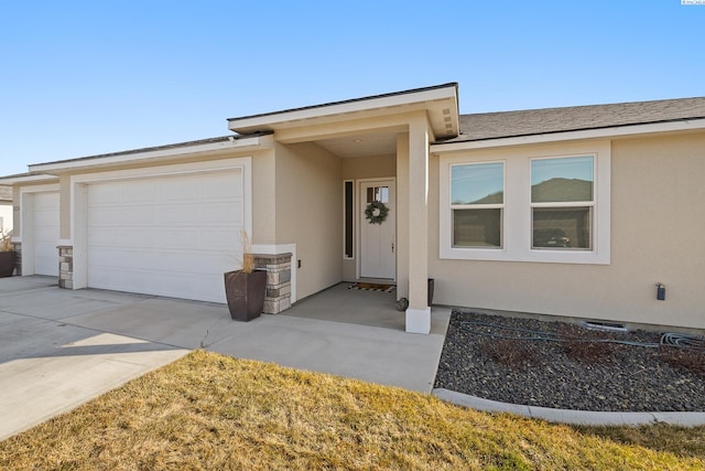 view of front of house with a shingled roof, driveway, an attached garage, and stucco siding