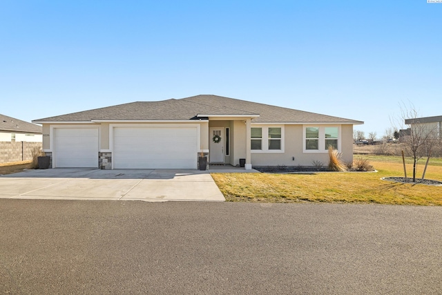 view of front of home featuring a front yard, concrete driveway, an attached garage, and stucco siding