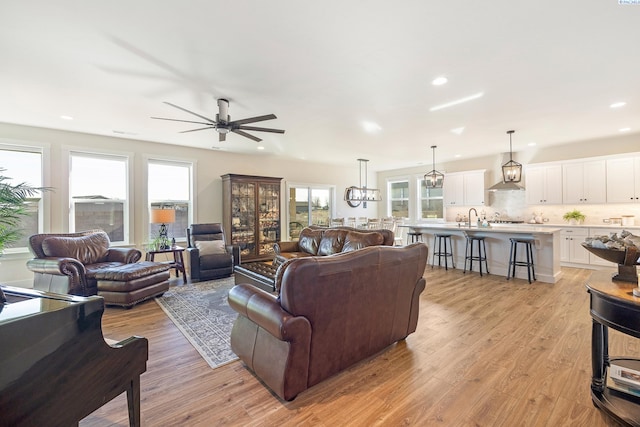 living area with a ceiling fan, recessed lighting, a healthy amount of sunlight, and light wood-style flooring