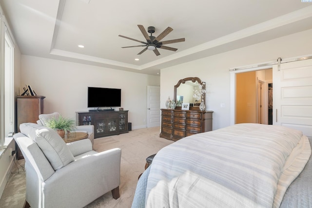 bedroom with ceiling fan, a barn door, recessed lighting, light carpet, and a tray ceiling