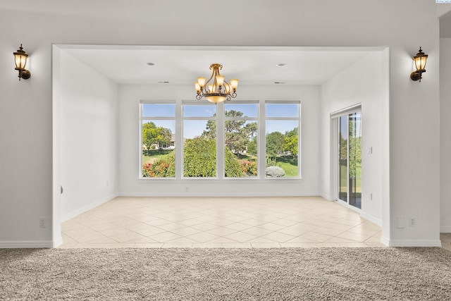 spare room featuring light carpet, light tile patterned floors, baseboards, and a chandelier