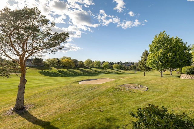 surrounding community with view of golf course and a yard