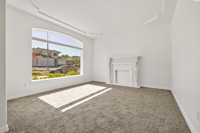 unfurnished living room featuring carpet floors and baseboards