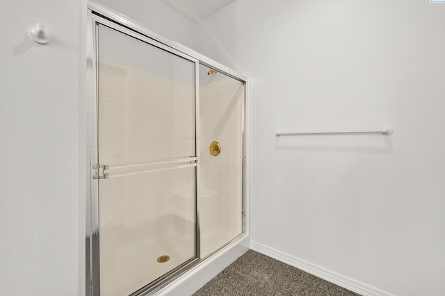 full bathroom featuring a stall shower and baseboards