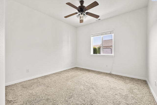 carpeted spare room with a ceiling fan, visible vents, and baseboards