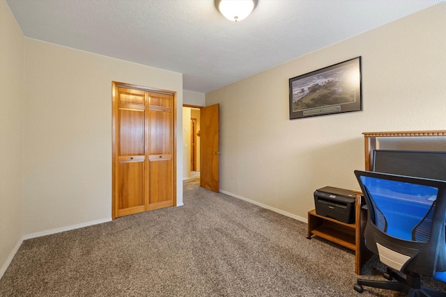 unfurnished office with carpet, a textured ceiling, and baseboards