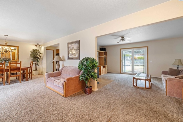 living area featuring a textured ceiling, carpet, and a notable chandelier