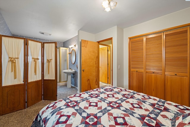 carpeted bedroom with connected bathroom, visible vents, and a closet