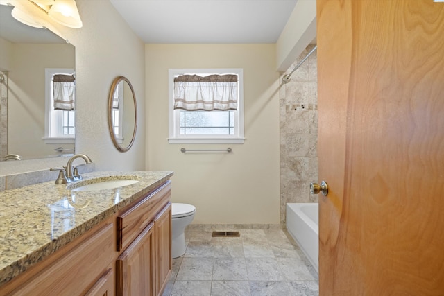 bathroom featuring baseboards, vanity, toilet, and a healthy amount of sunlight