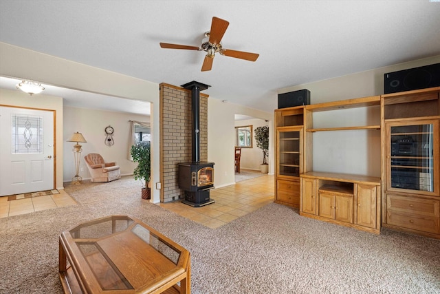 unfurnished living room with light carpet, a wood stove, and light tile patterned floors