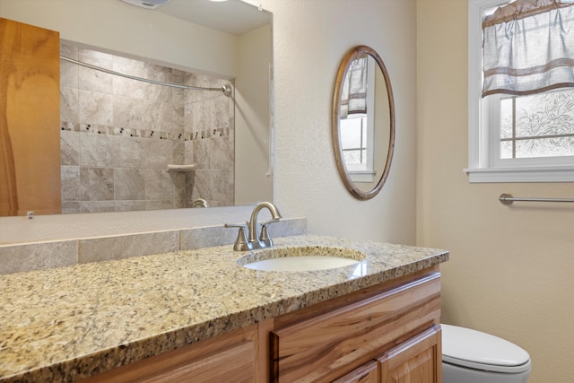 full bath featuring a shower, vanity, and toilet