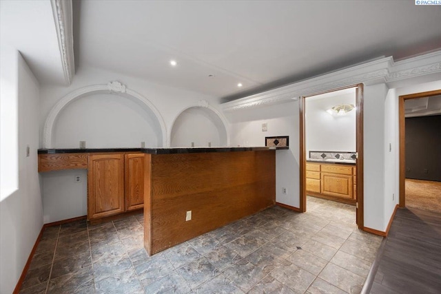 823 S 5th Ave, Pasco, WA 99301 - kitchen featuring brown cabinetry, recessed lighting, stone finish floors, a peninsula, and dark countertops