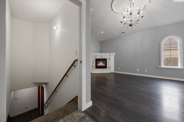 823 S 5th Ave, Pasco, WA 99301 - unfurnished living room featuring dark wood-style floors, a chandelier, a premium fireplace, and vaulted ceiling