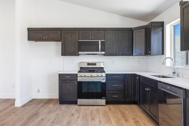 2925 S Osborne St, Kennewick, WA 99338 - kitchen featuring appliances with stainless steel finishes, a sink, lofted ceiling, light countertops, and backsplash