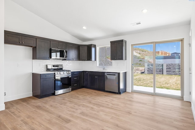 2925 S Osborne St, Kennewick, WA 99338 - kitchen featuring appliances with stainless steel finishes, a sink, tasteful backsplash, light countertops, and vaulted ceiling