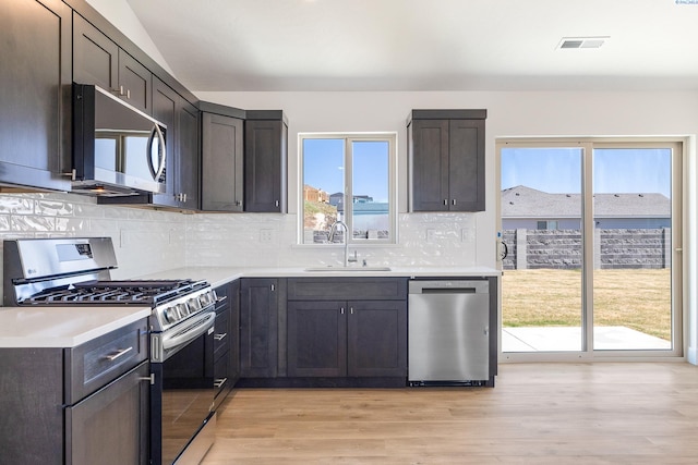 2925 S Osborne St, Kennewick, WA 99338 - kitchen featuring appliances with stainless steel finishes, a sink, light wood-style floors, backsplash, and light countertops