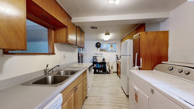 1810 NE Wheatland Dr, Pullman, WA 99163 - kitchen featuring white appliances, visible vents, separate washer and dryer, a sink, and light countertops