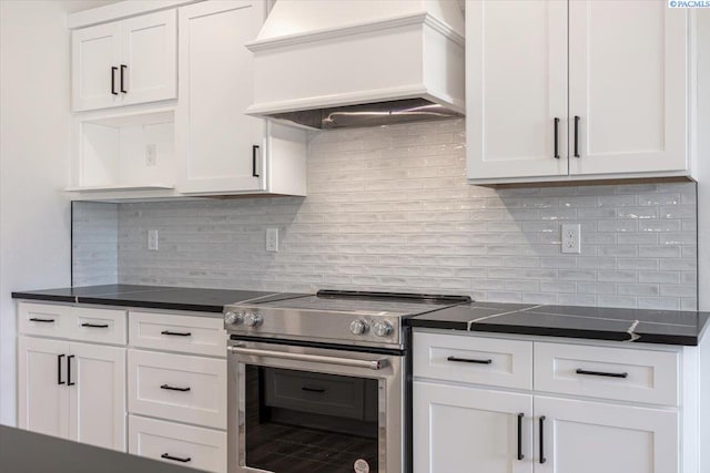 1839 S Union St, Kennewick, WA 99337 - kitchen featuring stainless steel electric range, custom exhaust hood, dark countertops, white cabinets, and decorative backsplash