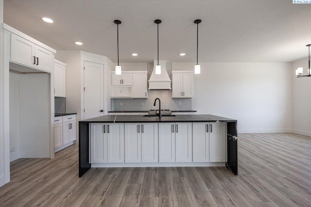 1839 S Union St, Kennewick, WA 99337 - kitchen featuring premium range hood, dark countertops, light wood finished floors, tasteful backsplash, and white cabinets