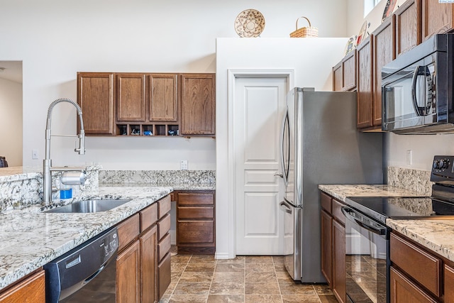 6110 Westport Ln, Pasco, WA 99301 - kitchen featuring black appliances, a sink, light stone counters, and brown cabinetry