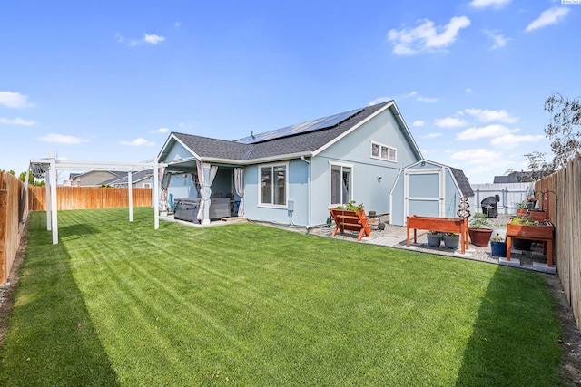 6110 Westport Ln, Pasco, WA 99301 - back of property featuring a hot tub, solar panels, a patio area, and roof with shingles