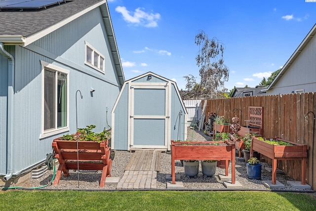 6110 Westport Ln, Pasco, WA 99301 - view of shed with a fenced backyard, solar panels, and a garden