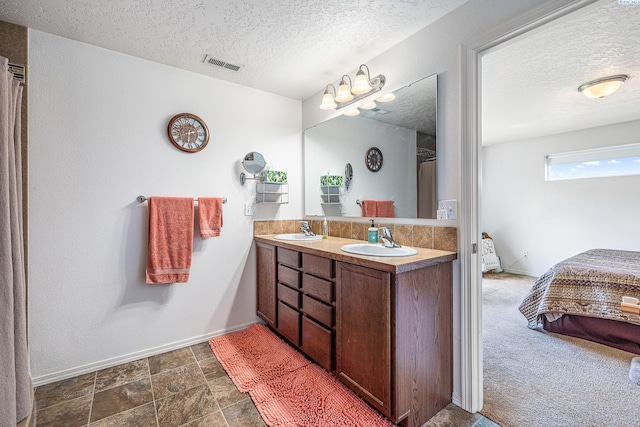 6110 Westport Ln, Pasco, WA 99301 - bathroom featuring a textured ceiling, ensuite bath, baseboards, and double vanity