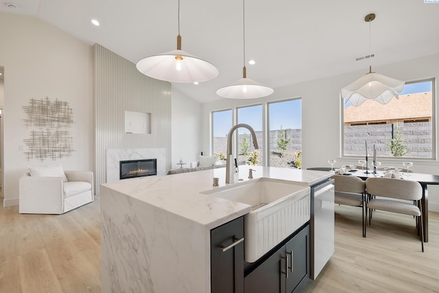 kitchen with a center island with sink, vaulted ceiling, plenty of natural light, and pendant lighting