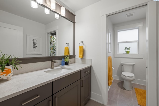 bathroom featuring vanity, toilet, and tile patterned flooring