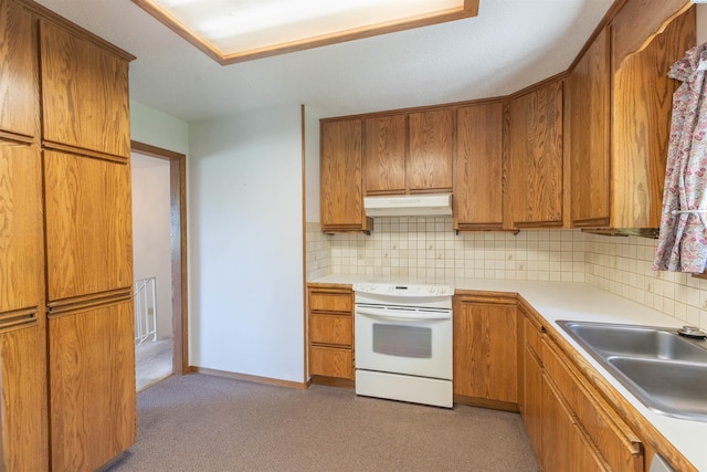 1835 NW Deane St, Pullman, WA 99163 - kitchen with white range with electric stovetop, under cabinet range hood, decorative backsplash, light countertops, and brown cabinetry