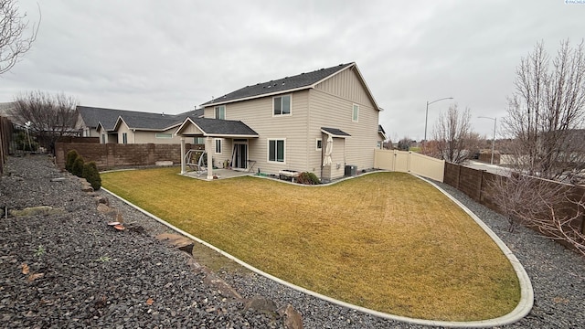 rear view of house featuring central AC unit, a patio area, and a lawn