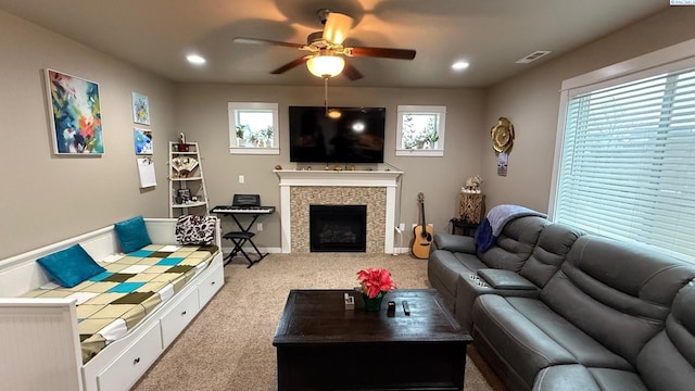 living room with ceiling fan, a fireplace, and carpet