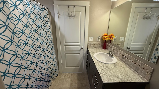 bathroom with a shower with curtain, vanity, and backsplash